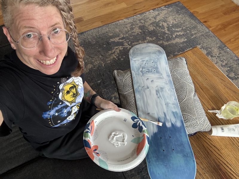 Selfie holding a skateboard deck freshly coated in white gesso