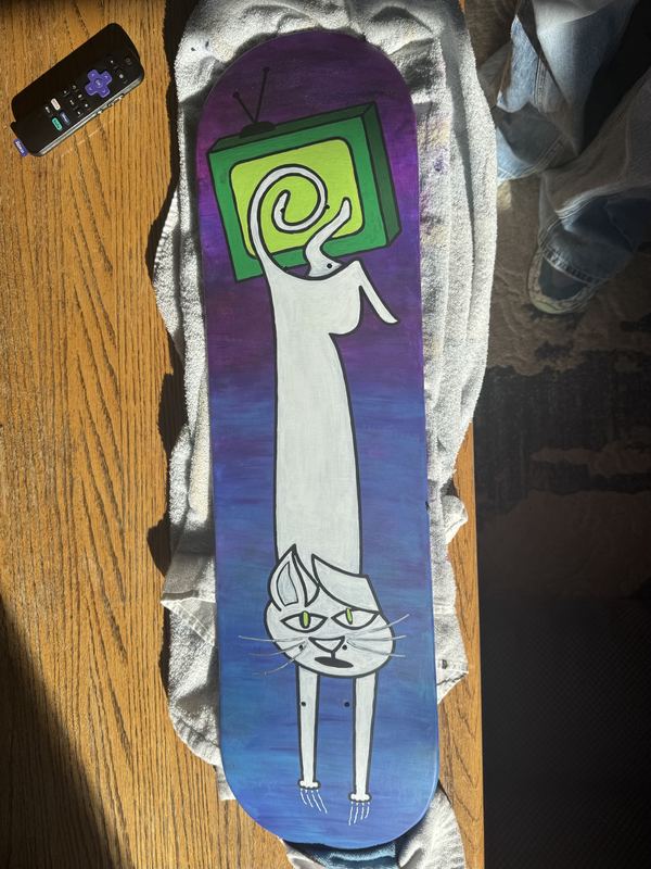 White cat deck on a table next to a green TV