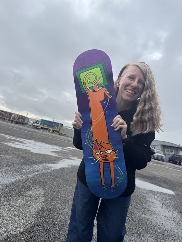 Rachel holding the finished skateboard deck