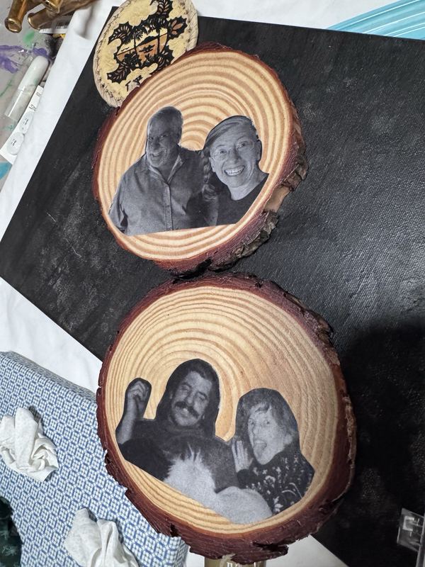 Two wood rounds with black and white photos of family members transferred onto them